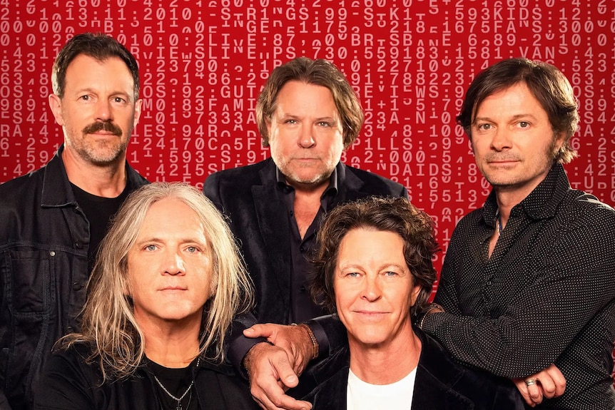 Fiver older male members of Brisbane band Powderfinger pose against red background with cryptic coding