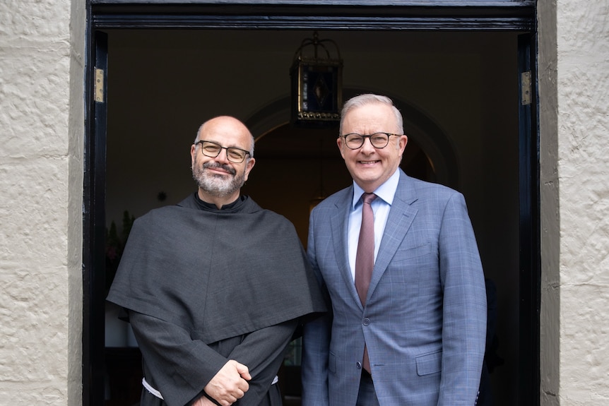Father Paolo Benanti standing next to Anthony Albanese in a doorway.