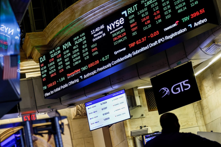 Screens display news about Anthropic's IPO.