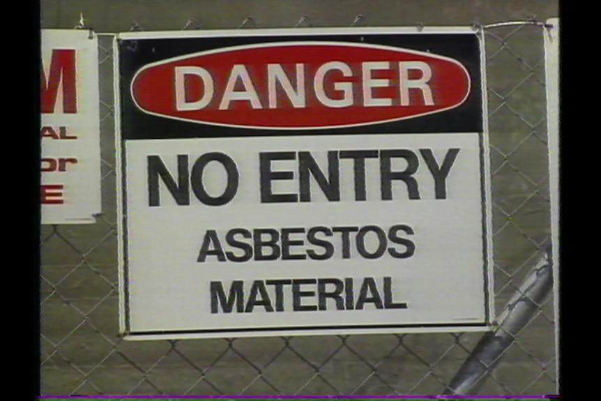 A warning sign reading: "DANGER, NO ENTRY, ASBESTOS MATERIAL."