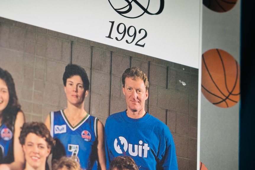 Ross Park, former coach of Tasmania's Islanders women's basketball team, with a basketball. Also in a group photo of team.
