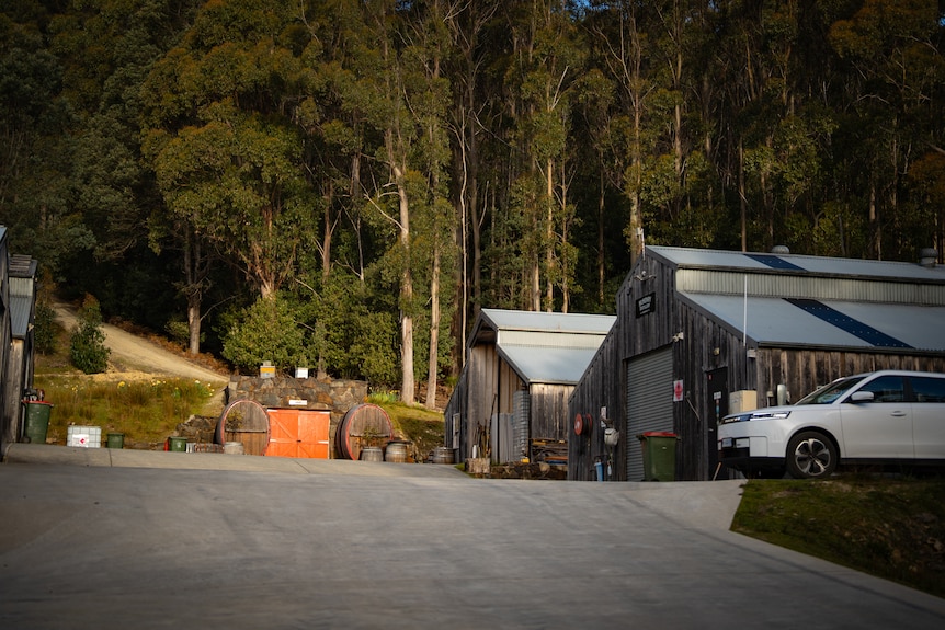 Barrels and a copper still in a modern looking large shed