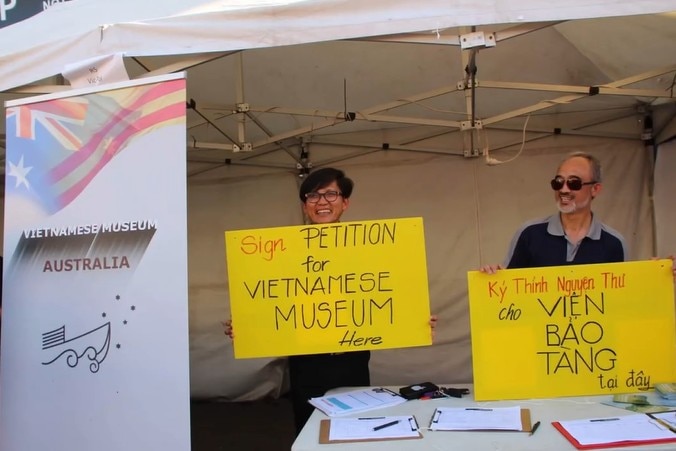 Two volunteers hold petition signs
