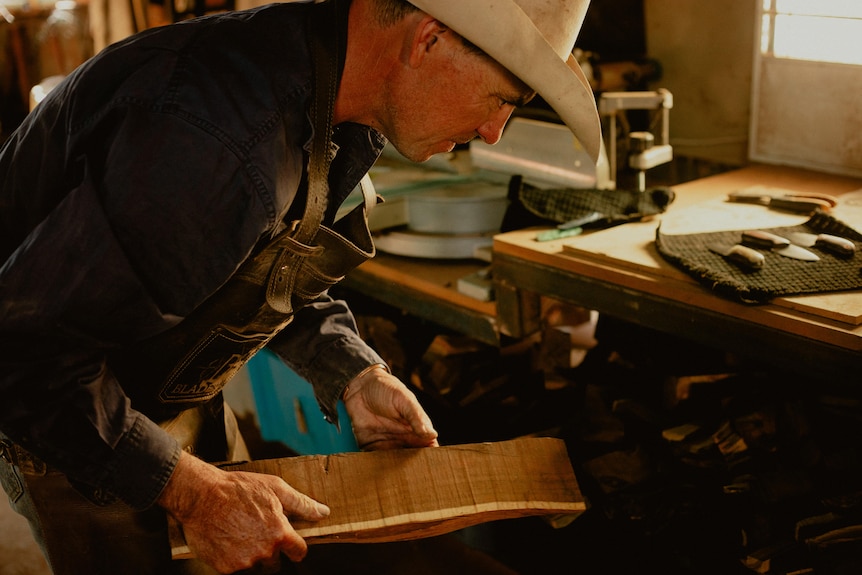 Bodie holds a piece of locally sourced timber, which he will use to make knife handles.