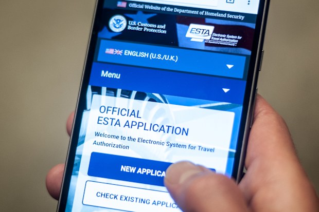A man accessing the US Department for Homeland Security's official Esta visa waiver application website on his mobile phone. The scheme requires international travellers who are exempt from visa requirements to apply for an Esta, which stands for Electronic System for Travel Authorisation, and pay a small fee - around Â£10 - before entering the territory. (Photo by Lauren Hurley/PA Images via Getty Images)