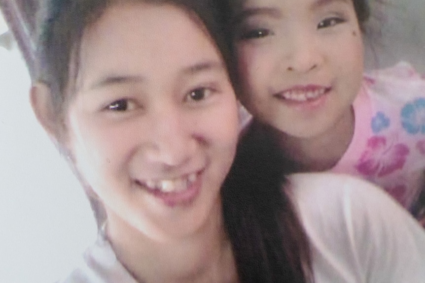 A selfie of a two smiling Thai girls with long dark hair.