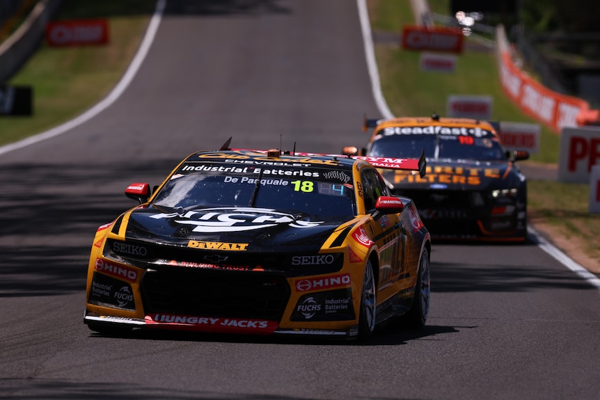 Two cars race up Mount Panorama