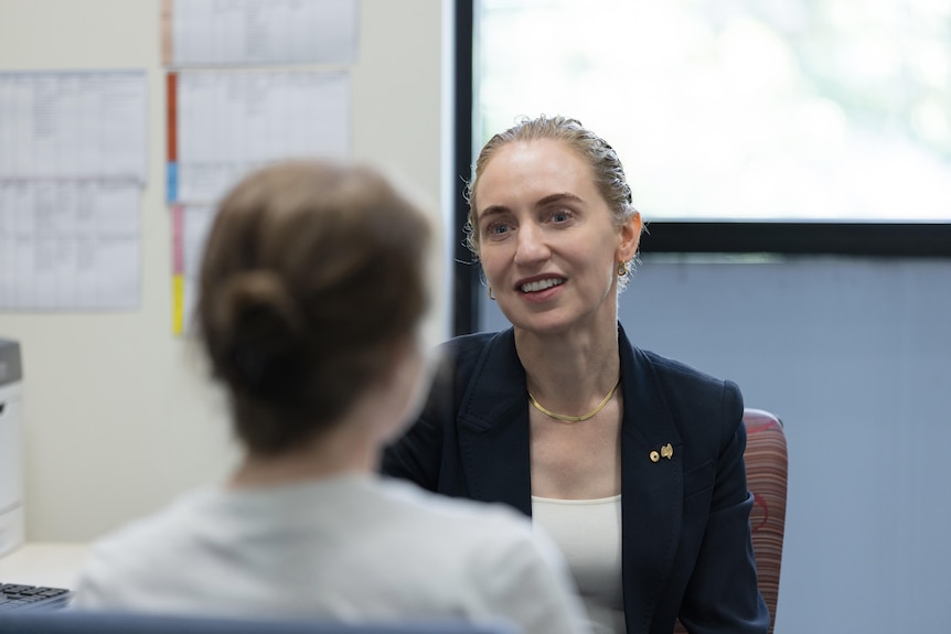 Professsor Georgina Long speaks to a person with their back to the camera.