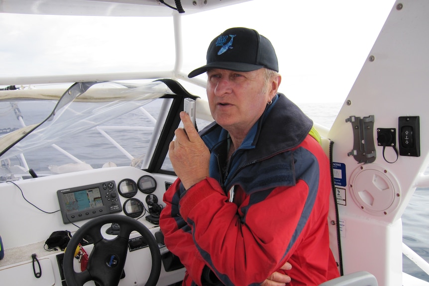 A man on a boat conducting whale surveys.