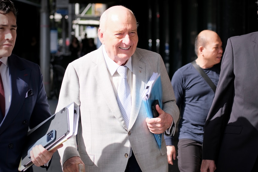 Alan Jones in grey suit and blue tie