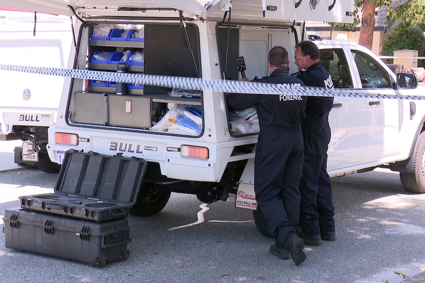 Forensic police officers working at the scene of a home that was shot at. 