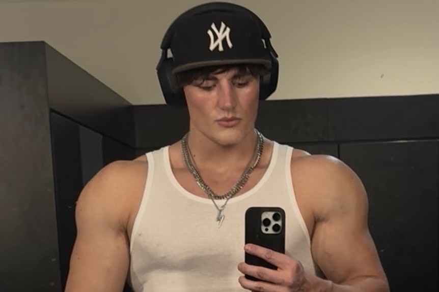 a man with gym-worked muscles and a white singlet top
