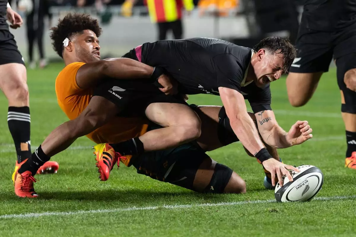 New Zealand's Leroy Carter, scores a try as Australia's Rob Valetini tackles him during a Bledisloe Cup rugby union test match in Auckland, New Zealand on Saturday, Oct. 10, 2026. (Brett Phibbs/Photosport via AP)