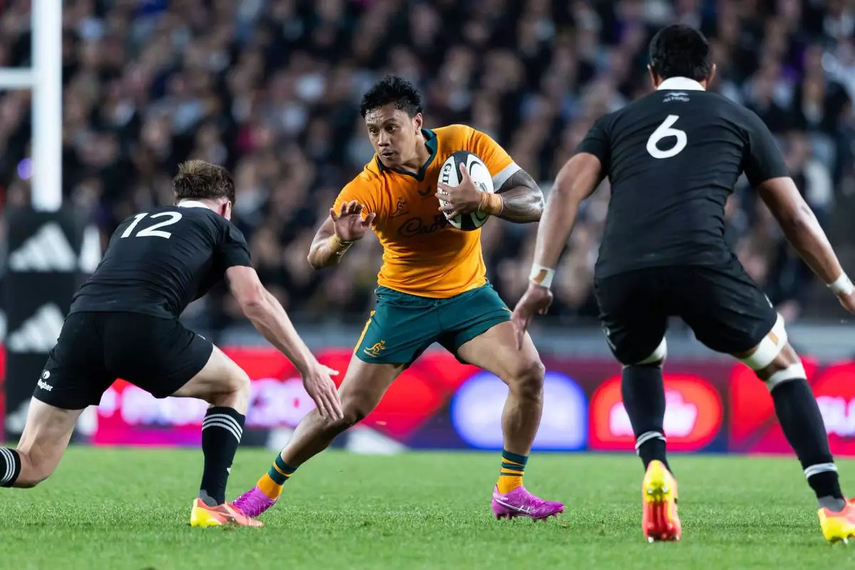 Australia's Len Ikitau, center, looks to split the defence of New Zealand's Jordie Barrett, left, and New Zealand's Tupou Vaa'i during a Bledisloe Cup rugby union test match in Auckland, New Zealand on Saturday, Oct. 10 2026. (Brett Phibbs/Photosport via AP)