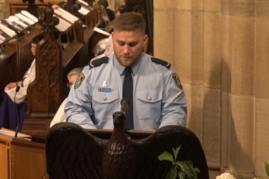 Man in police uniform speak at church lectern