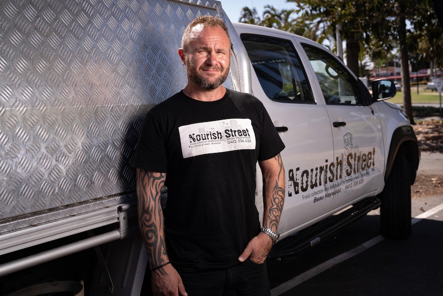 A man leaning against a ute