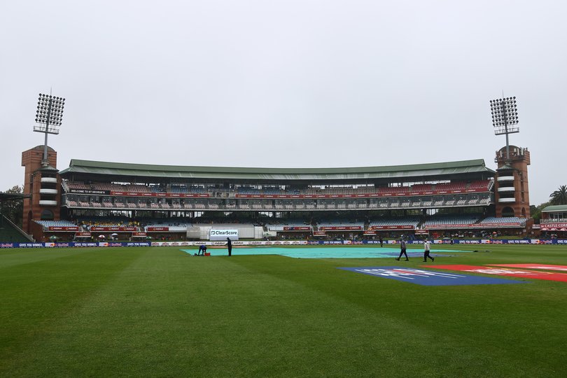 A general view as ground crew cover the field with tarp.