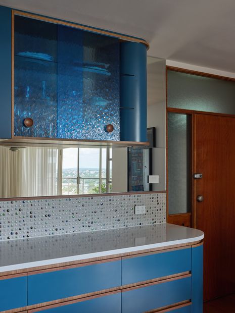A mirrored splashback reflects the view and bounces light into the space. Artworks (L–R): Adrienne Williams, Maree Puruntatameri.