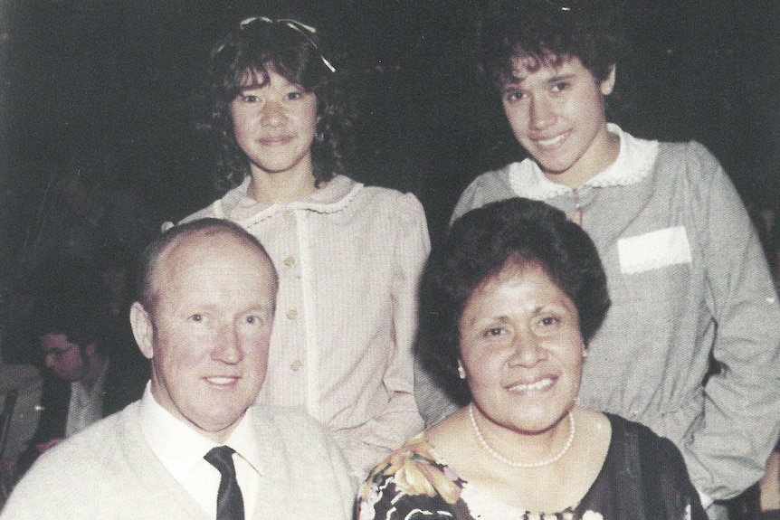 Young Tongan-Australian sisters pose in formal wear with their mother and father