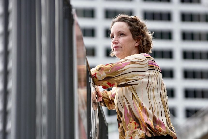 A woman looking away while leaning on a railing