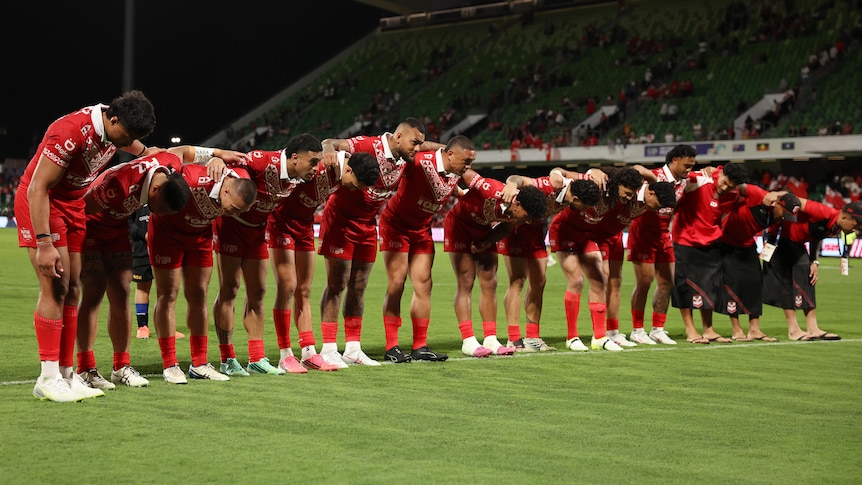 The Tongan men's rugby league team bows to the crowd after a win at the Rugby League World Cup. 