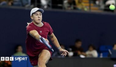 Sonay Kartal, in deep red tennis kit and white cap, plays a forehand shot at the Wuhan Open