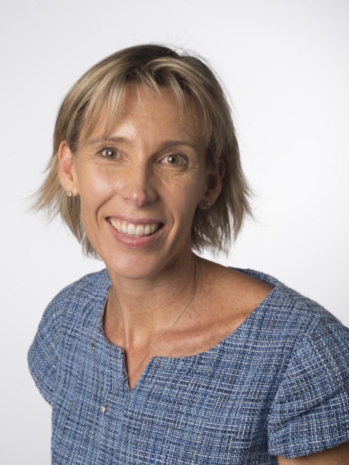A woman with short blonde hair smiling.