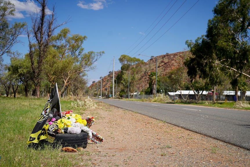 Flowers and a Richmond Tigers AFL flag sit on the side of Len Kittle Drive where a 57-year-old man was struck and killed.