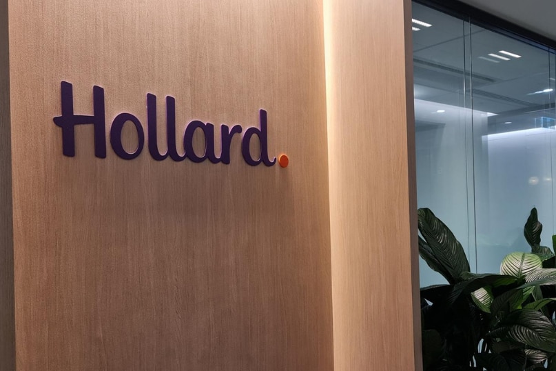 A Hollard insurance logo on a wooden wall inside an office.