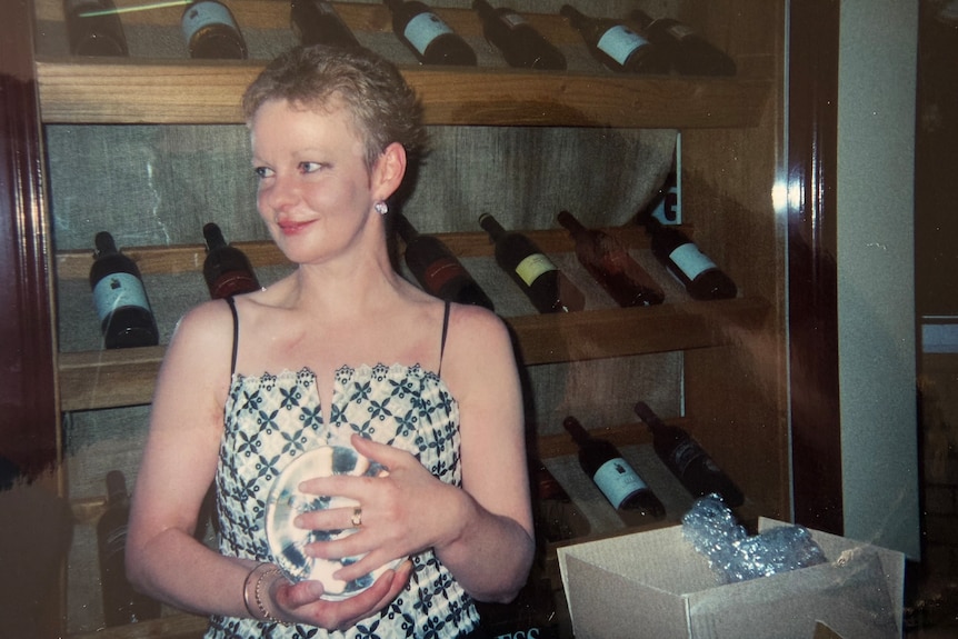 A woman with short hair looks to one side with a slight smile.