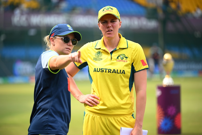 Alyssa Healy points as teammate Tahlia McGrath looks on.