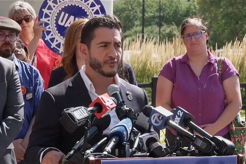 Abdul El-Sayed, wearing a dark suit, speaks at a lectern
