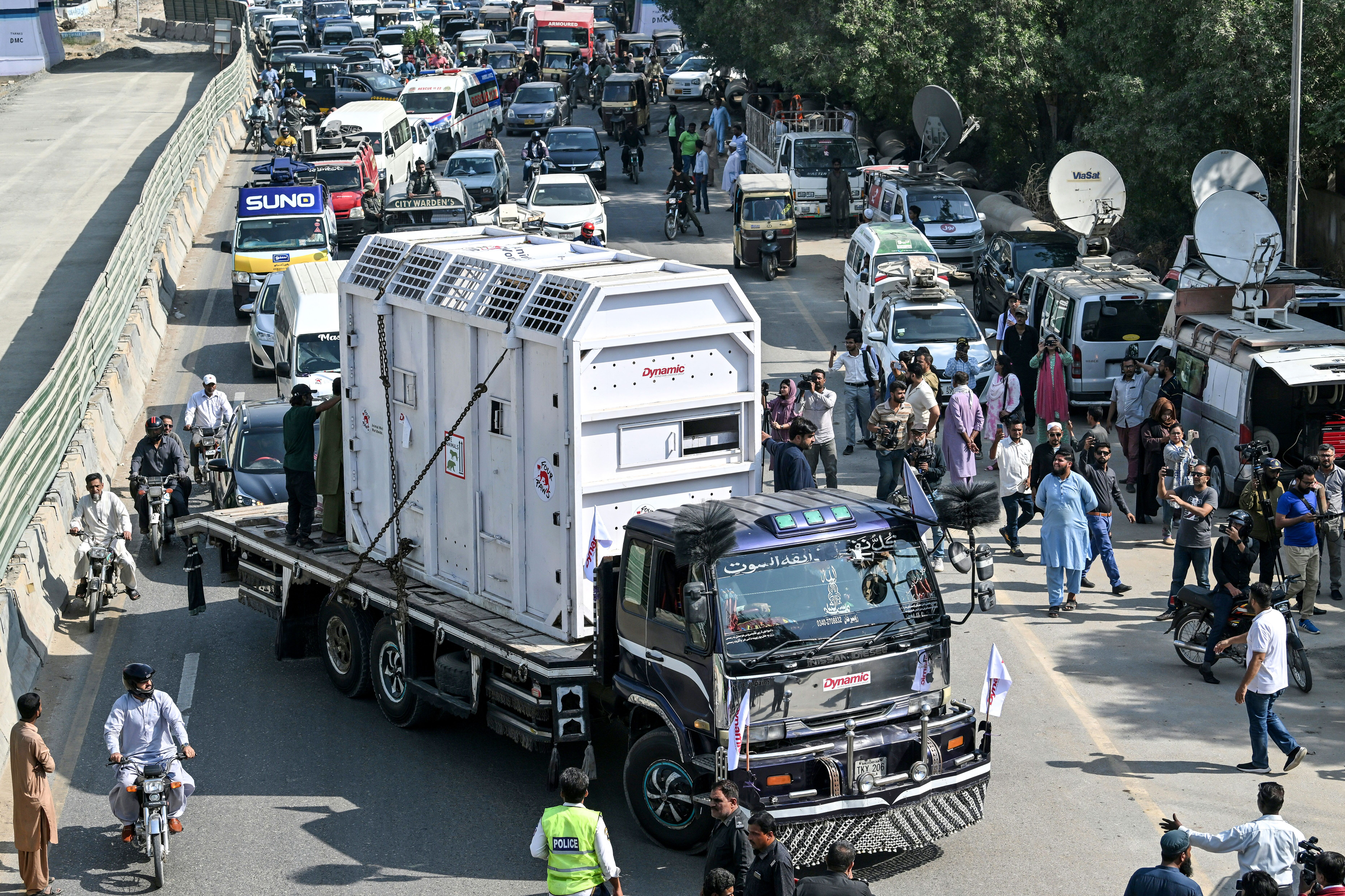 A truck carrying a travel cage for an elephant, Madhubala, passes from a street to be relocated from the Karachi Zoological Garden to a safari park in Karachi on November 26, 2024. (Photo by Asif HASSAN / AFP)