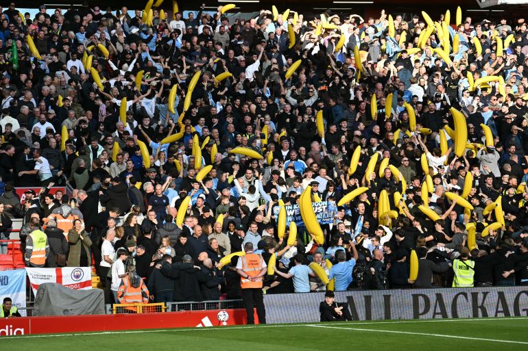 City fans wave inflatable bananas in the crowd ahead of the English Premier League football match between Liverpool and Manchester City at Anfield in Liverpool, north west England on October 11, 2026. (Photo by Paul ELLIS / AFP) / RESTRICTED TO EDITORIAL USE. NO USE WITH UNAUTHORIZED AUDIO, VIDEO, DATA, FIXTURE LISTS, CLUB/LEAGUE LOGOS OR 'LIVE' SERVICES. ONLINE IN-MATCH USE LIMITED TO 120 IMAGES. AN ADDITIONAL 40 IMAGES MAY BE USED IN EXTRA TIME. NO VIDEO EMULATION. SOCIAL MEDIA IN-MATCH USE LIMITED TO 120 IMAGES. AN ADDITIONAL 40 IMAGES MAY BE USED IN EXTRA TIME. NO USE IN BETTING PUBLICATIONS, GAMES OR SINGLE CLUB/LEAGUE/PLAYER PUBLICATIONS. /