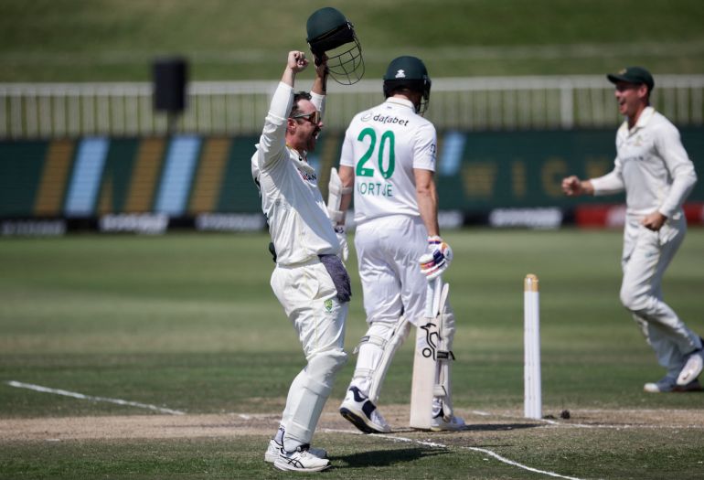Australia's Travis Head (L) celebrates after the dismisal of South Africa's Anrich Nortje (C/20) to seal victory for Australia on day five of the first Test match between South Africa and Australia at the Kingsmead stadium in Durban on October 13, 2026. (Photo by Marco Longari / AFP)