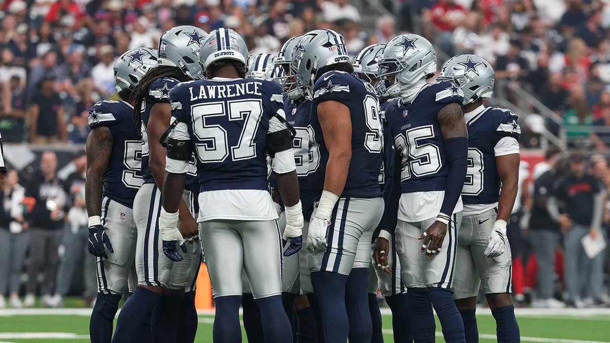 Dallas Cowboys defenders huddle up during an NFL game in Houston.