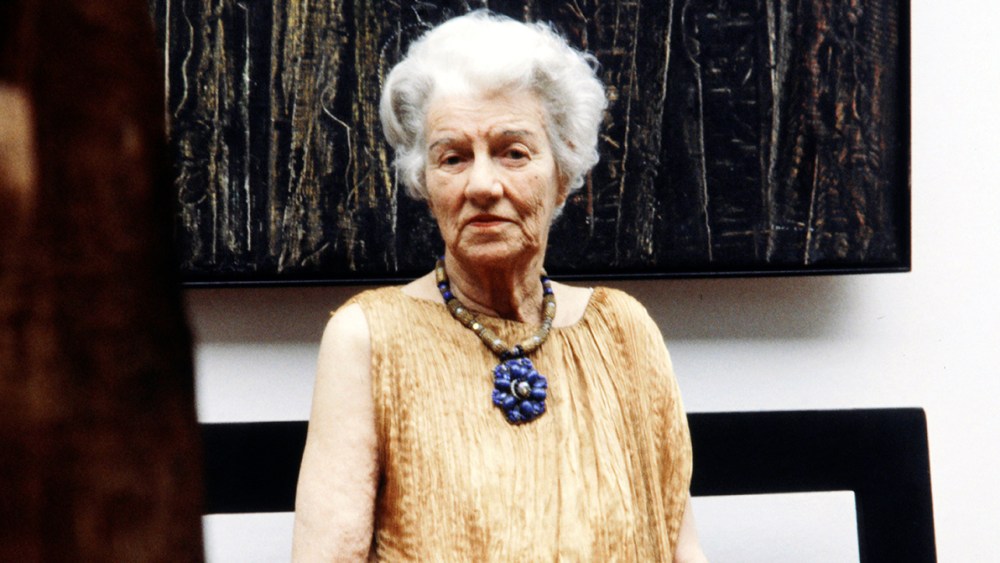 Peggy Guggenheim at her Venice home and museum in 1979. She wears a gold Fortuny evening dress and jewelry of her own.