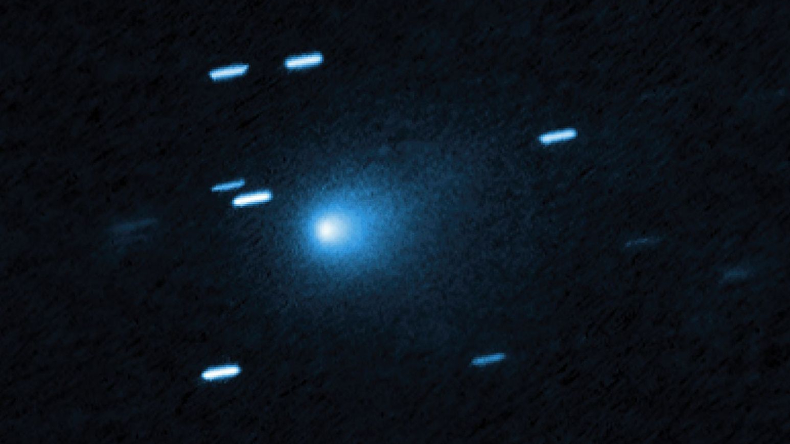 A blue ball of light shines between streaks of blueish light from stars in outer space