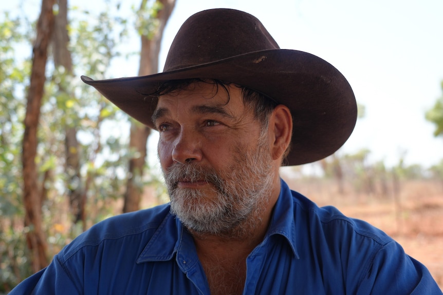 Man in blue shirt in front of an outback red dirt