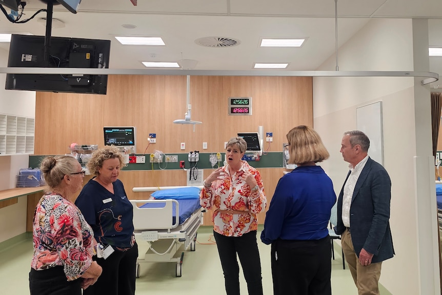 Politicians and media visit a new hospital.