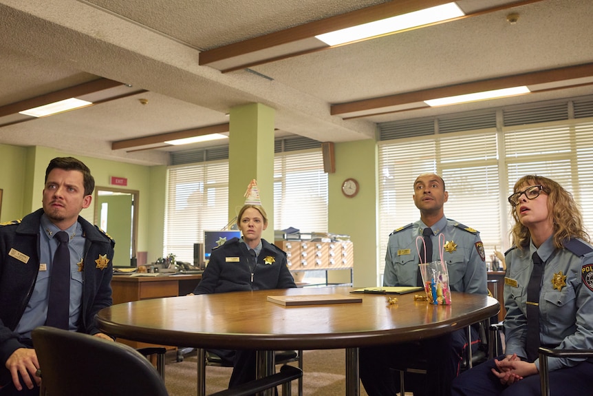 Police officers sit around a table
