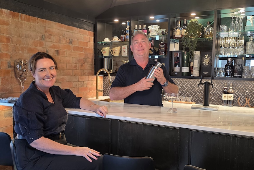 couple at bar, man holding cocktail shaker