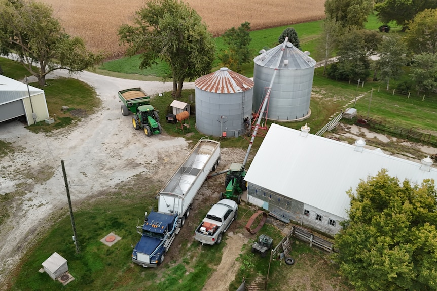 An aerial view of grain silos and heavy machinery on a farm.