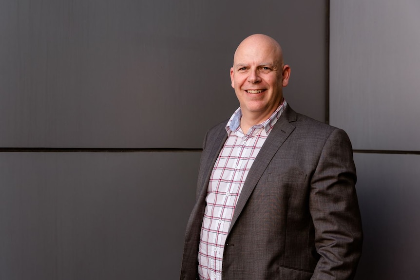 Simon Graafhuis smiling in a suit.