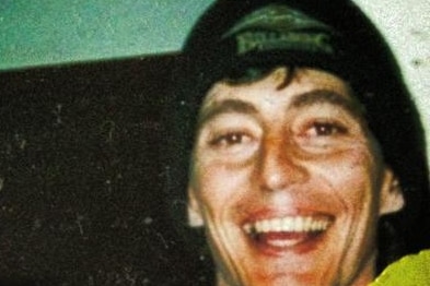 Man wearing a beanie smiles.