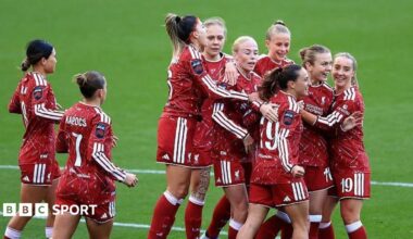 Liverpool players, wearing red, celebrate the opening goal