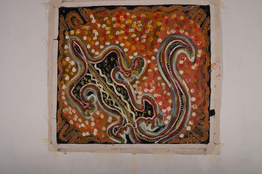 A red, black and brown painting of a goanna on canvas.