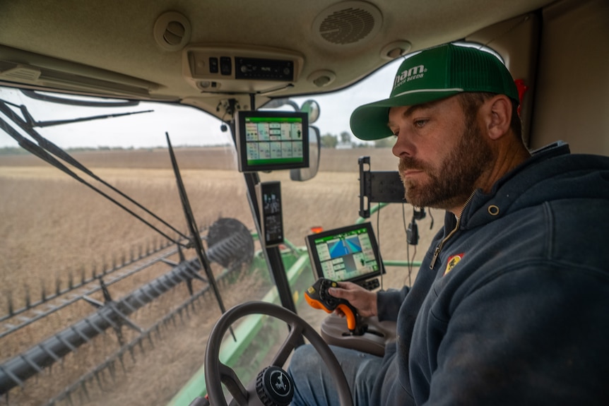 Thomsen inside the cab of a crop harvester.