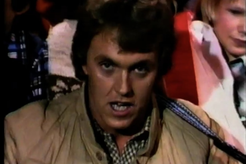 A younger Mike Brady in a beige jacket