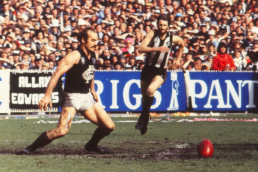  Carlton football player Alex Jesaulenko playing on a muddy field in a Carlton uniform.